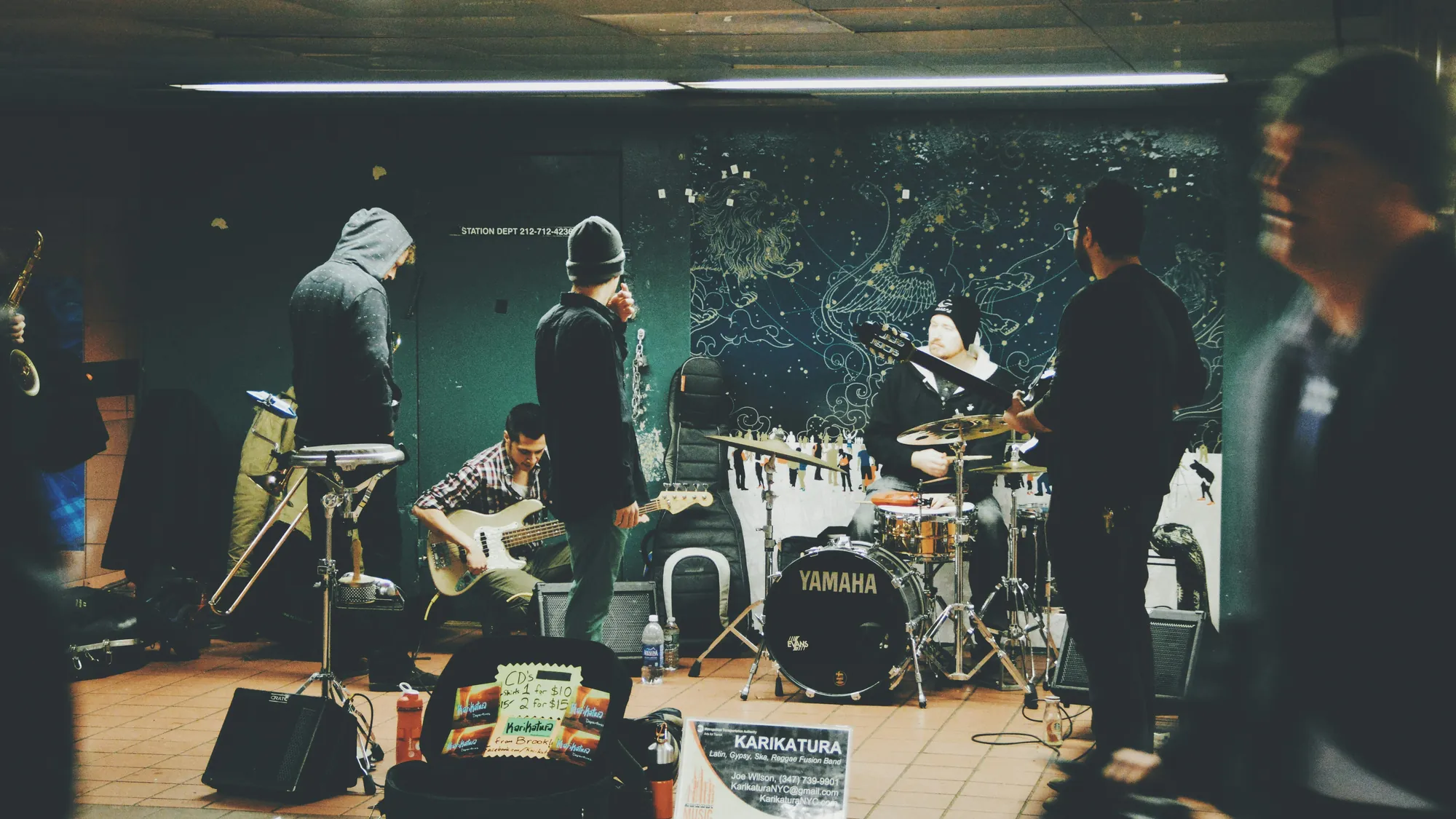 Una band suona insieme in una stanza, fra batteria, chitarre e amplificatori
